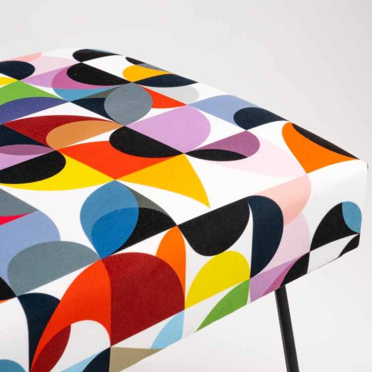 Panca imbottita con motivi colorati e gambe a forma di spillo