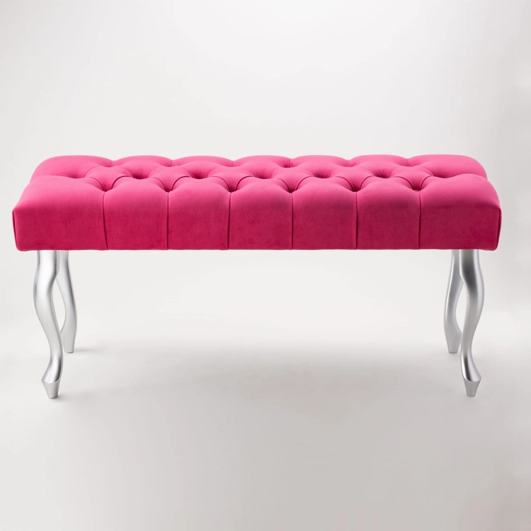 Un'elegante panca trapuntata in un intenso colore fucsia con gambe argentate.
