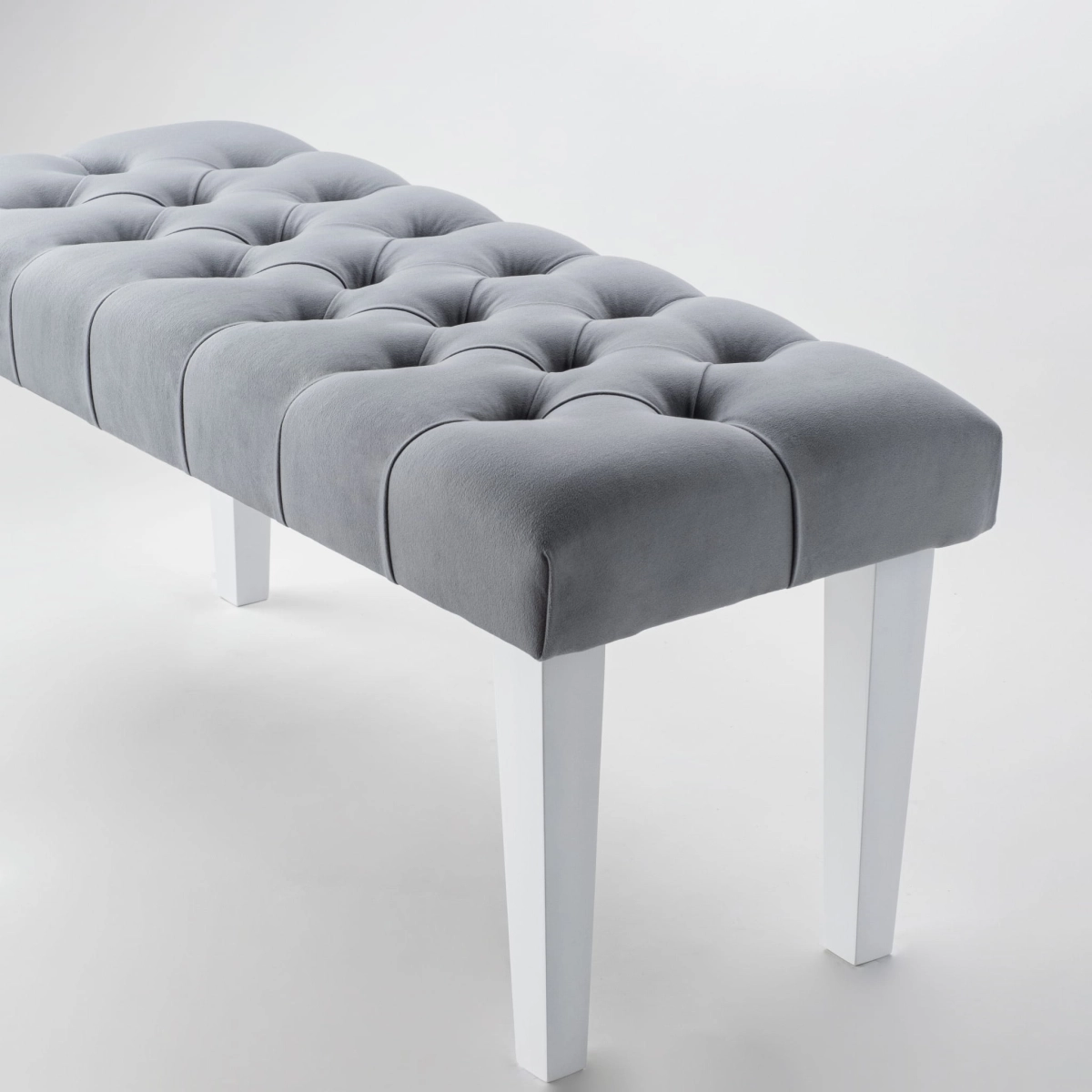 Elegante panca grigia con rivestimento trapuntato e gambe bianche