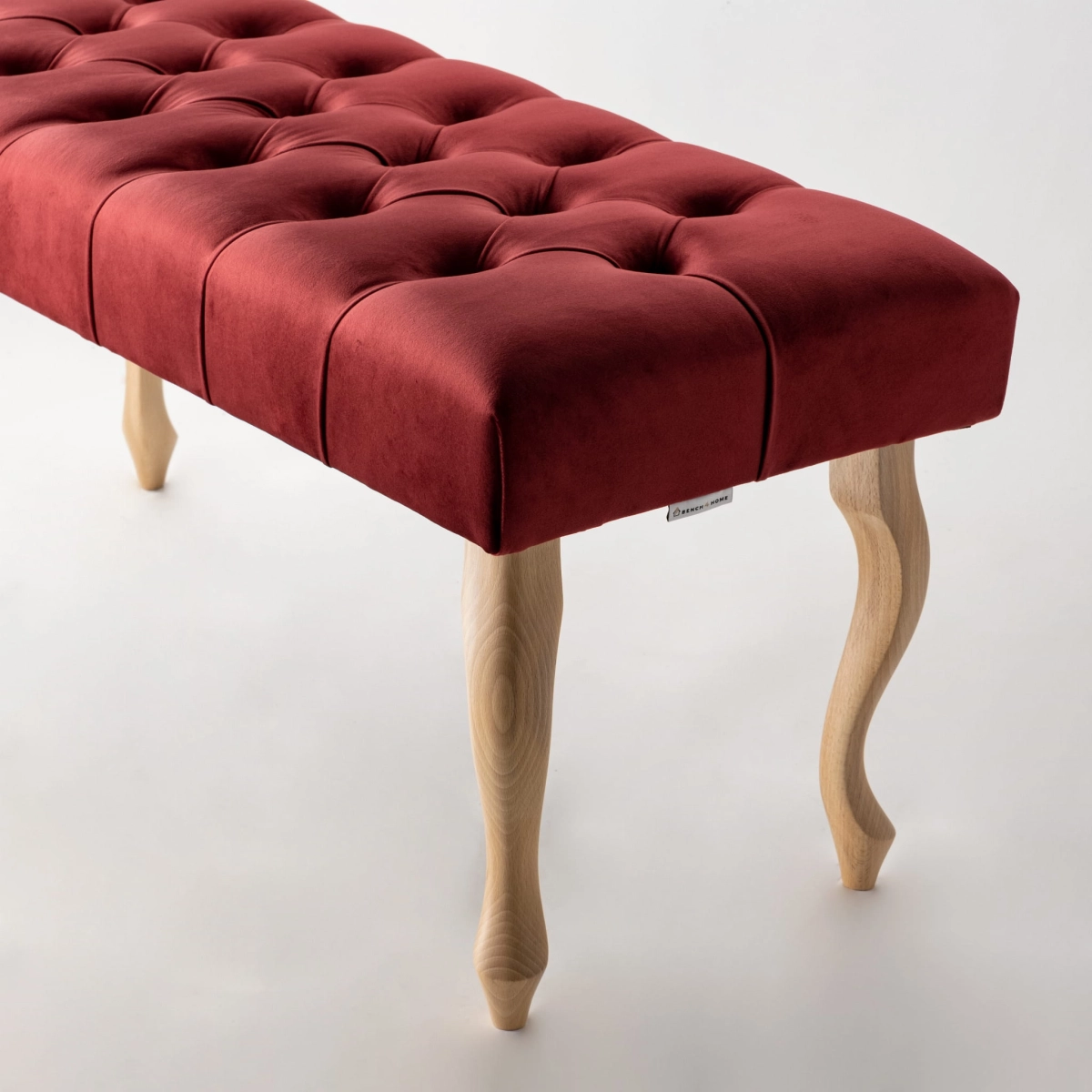Elegante panca capitonné bordeaux con gambe in legno